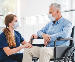 Man Talking To His Caregiver Sitting in A Wheelchair — Mobility Shop In Tweed Heads, NSW
