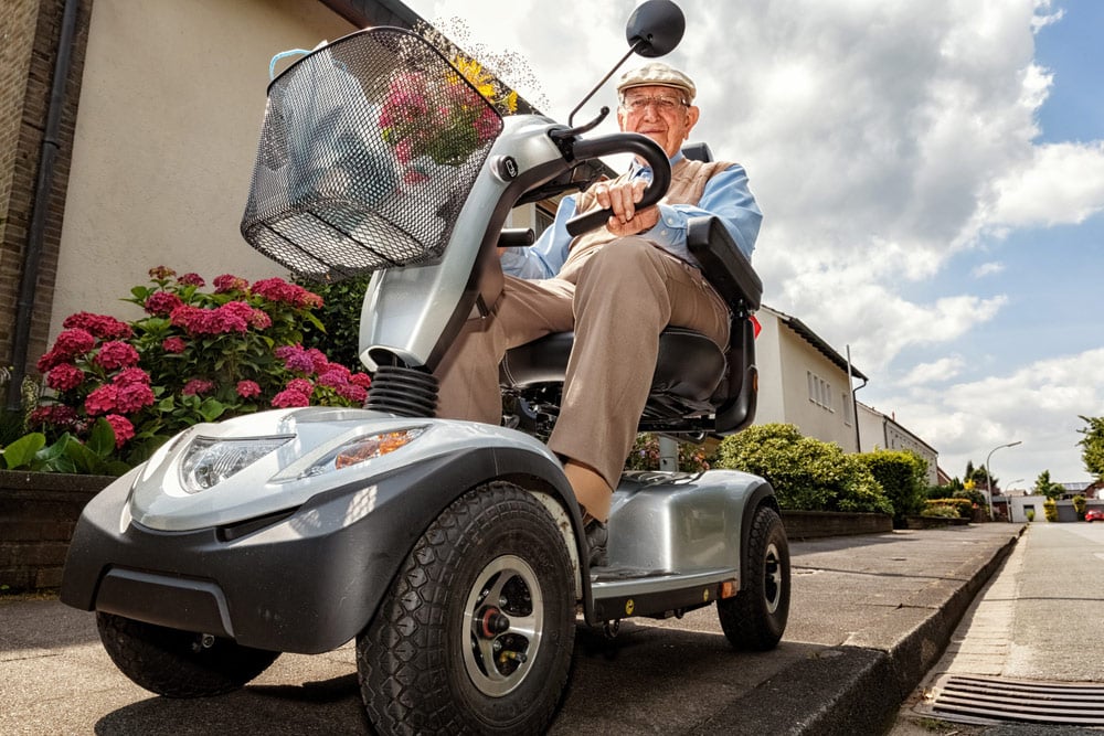 Elderly Person Drives A Mobility Scooter — Mobility Shop In Tweed Heads, NSW