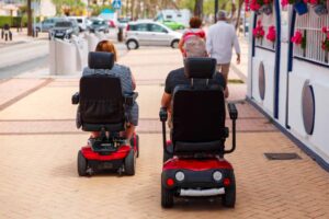 Elderly Couple Using An Electric Scooter