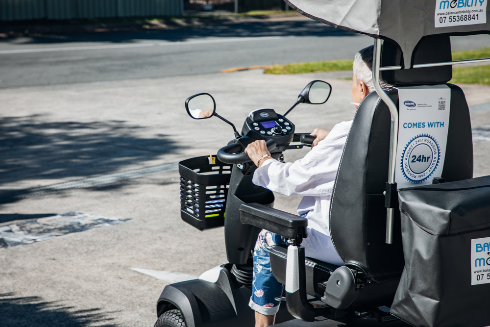 Senior Lady Riding In A Mobility Scooter