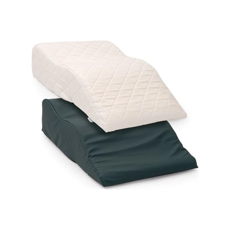 A white quilted wedge cushion stacked on a dark green wedge cushion against a plain white background.