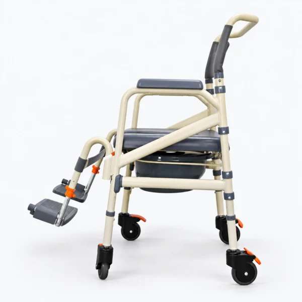 A beige folding transport chair with black seat and handles stands on small wheels against a white background, with a footrest attached on the left side.