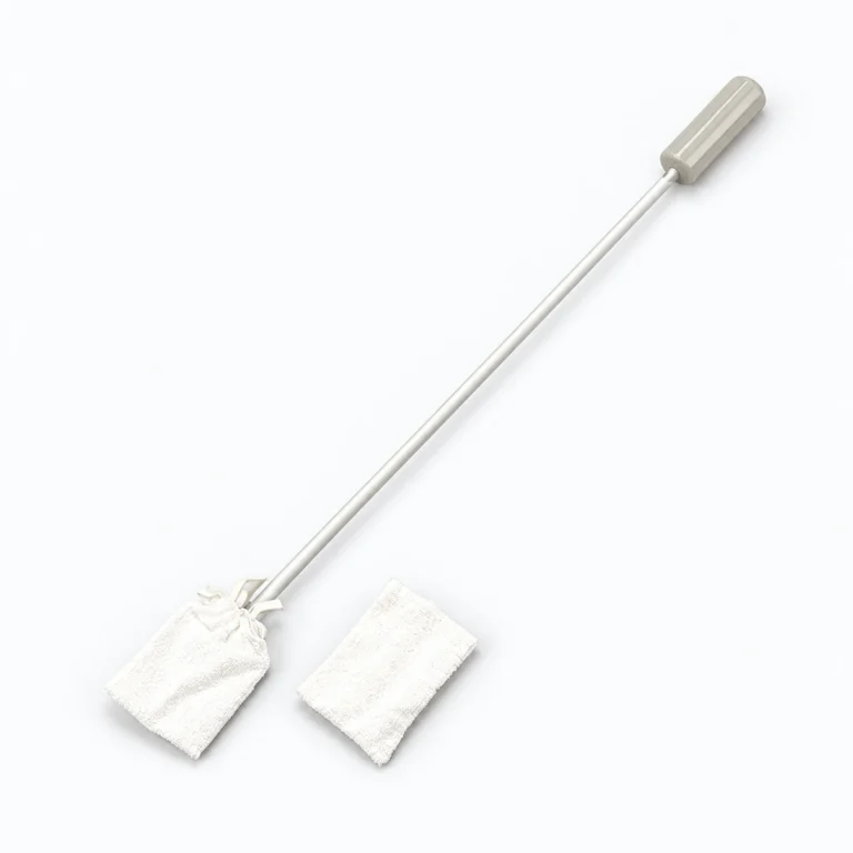 A long-handled cleaning mop with a gray grip lies diagonally on a white background, beside two white replacement mop pads.